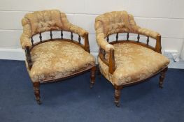 A PAIR OF EDWARDIAN WALNUT BUTTONED ARMCHAIRS, with spindled back, on ceramic casters