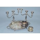 A PAIR OF SILVER PLATED THREE LIGHT CANDELABRA, together with two plated bottle coasters and an oval