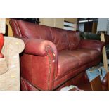 A BURGUNDY LEATHER TWO PIECE LOUNGE SUITE, comprising of two three seater sofa's