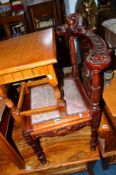 A REPRODUCTION CARVED WOOD CORNER CHAIR, with drop in seat, a yew wood occasional table with a