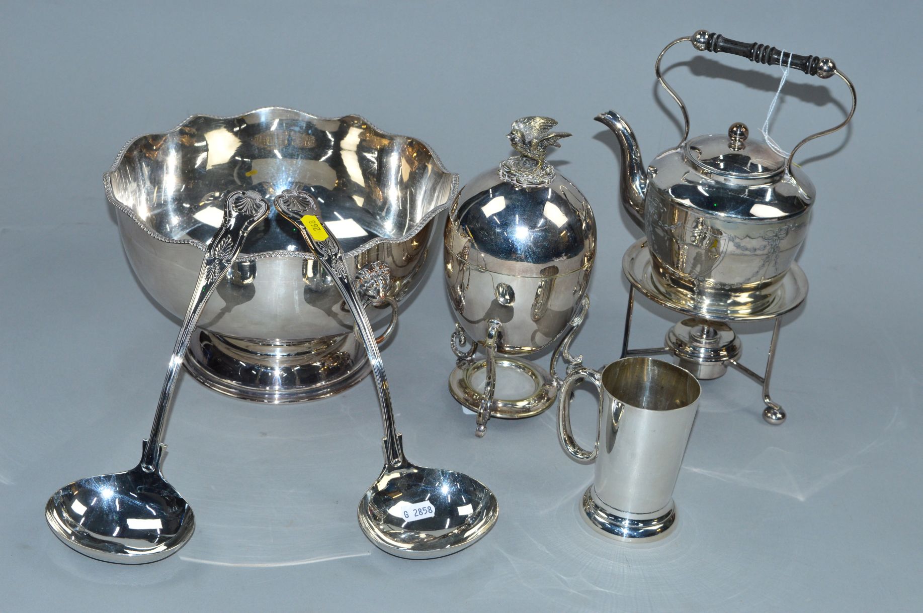A GROUP OF SILVER PLATE COMPRISING A PUNCH BOWL AND TWO LADLES,a spirit kettle on stand, an egg