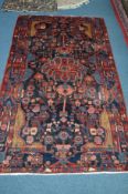 A 20TH CENTURY RED AND BLACK GROUND WOOLLEN CARPET SQUARE, with foliate and animal designs, (heavily