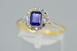 AN EARLY TO MID 20TH CENTURY SAPPHIRE AND DIAMOND DRESS RING, a bright blue emerald cut sapphire