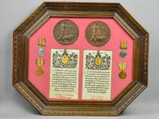 A LARGE EIGHT SIDED WOODEN GLAZED FRAME CONTAINING MEMORIAL DEATH PLAQUES, MEDALS AND MEMORIAL