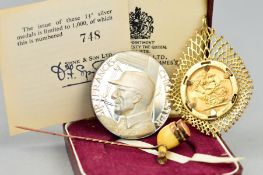 A FULL GOLD SOVEREIGN, mounted in a 9K setting, approximate weight 14 grams, a Spink medal in silver