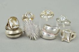 EIGHT RINGS, of varying designs to include paste and cubic zirconia set, cross over design etc,