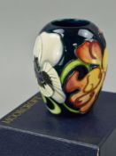 A SMALL BOXED MOORCROFT POTTERY VASE, 'Miss Alice' pattern, impressed and painted marks to base,