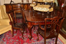 AN EARLY 20TH CENTURY MAHOGANY DINING SUITE comprising of a wind out table with moulded edges on