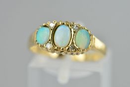 A 9CT GOLD OPAL AND DIAMOND RING, designed as three oval opal cabochons each interspaced by two