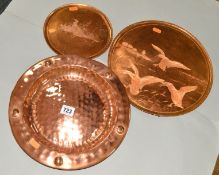 A CIRCULAR COPPER DISH, hand hammered finish, approximate diameter 29.5cm, together with two