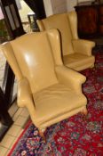 A PAIR OF TANNED LEATHER WING BACK ARMCHAIRS (sd)