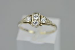 A DIAMOND DRESS RING, designed with two brilliant cut diamonds to the central rectangular panel,