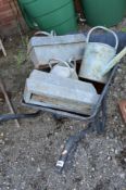 A WHEELBARROW CONTAINING FIVE GALVANISED ITEMS