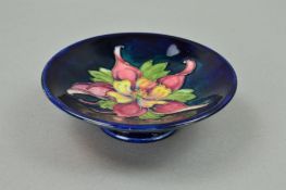 A MOORCROFT POTTERY FOOTED TRINKET DISH, 'Columbine' pattern