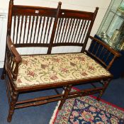AN EDWARDIAN TWO SEATER SOFA with turned spindle back and armrests
