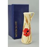 A BOXED MOORCROFT POTTERY JUG, 'Harvest Poppy' pattern, on cream ground, with impressed and sticky