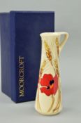 A BOXED MOORCROFT POTTERY JUG, 'Harvest Poppy' pattern, on cream ground, with impressed and sticky