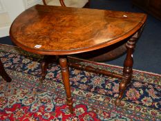 A VICTORIAN OVAL TOPPED SUTHERLAND TABLE on scrolled legs united by a turned stretcher on brass