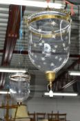 TWO SIMILAR EARLY 20TH CENTURY BRASS AND GLASS DOMED CEILING LIGHTS, one with a lid and one etched