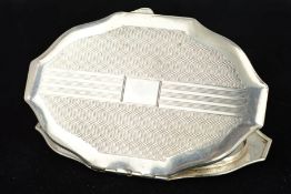 A MID 20TH CENTURY SILVER COMPACT, of shaped oval outline, with engine turned decoration and