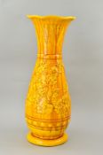 A BURMANTOFTS FAIENCE FLOOR STANDING BALUSTER VASE, yellow glazed wavy rim, incised and relief