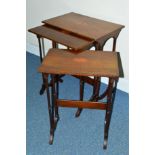 AN EDWARDIAN MAHOGANY AND INLAID NEST OF THREE TABLES, on slender turned column supports, shaped