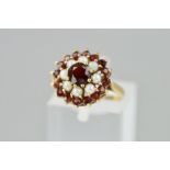 A MID TO LATE 20TH CENTURY SEED PEARL AND GARNET ROUND CLUSTER RING, ring size K1/2, hallmarked