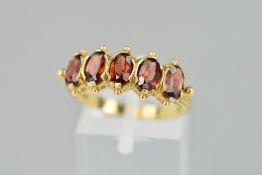 A 9CT GOLD GARNET FIVE STONE RING, designed as five stone ring, designed as five oval garnets with
