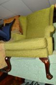 A GREEN UPHOLSTERED WING BACK CHAIR