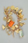 A 9CT GOLD CHARM BRACELET, the curb link chain suspending twenty one charms to include a thistle and