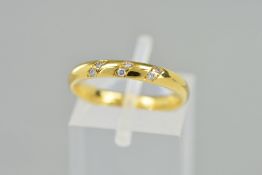 AN 18CT GOLD DIAMOND BAND RING, the plain band set with six brilliant cut diamonds set in three