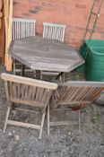 A TEAK GARDEN TABLE and four folding chairs (5)