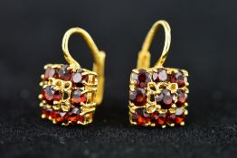 A PAIR OF GARNET EARRINGS, each of square outline claw set with nine circular garnets to the ear