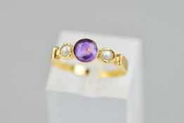 AN EARLY 20TH CENTURY AMETHYST AND PEARL RING, the central circular amethyst flanked by a split