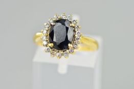 AN 18CT GOLD SAPPHIRE AND DIAMOND CLUSTER RING, the oval sapphire within a brilliant cut diamond
