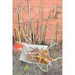 A WHEELBARROW and a quantity of garden tools including shovels, spades etc (over 20)