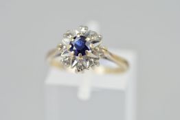 AN 18CT GOLD SAPPHIRE AND DIAMOND CLUSTER RING, the central circular sapphire atop a star design