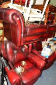 A BURGUNDY LEATHER THREE PIECE LOUNGE SUITE comprising of a two seater sofa and a pair of