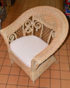 A WICKER CONSERVATORY CHAIR, scroll and lattice design back, loose cushion to seat (situated in