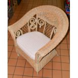 A WICKER CONSERVATORY CHAIR, scroll and lattice design back, loose cushion to seat (situated in