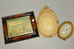 TWO OVAL GILT PICTURE FRAMES, together with a reproduction oil on canvas of fishing boats at sea (