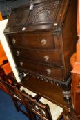 AN OAK DRAW LEAF TABLE on acorn legs, an oak fall front bureau, a two door cabinet, two chairs,