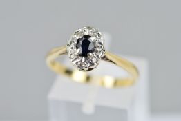 A 9CT GOLD SAPPHIRE AND DIAMOND CLUSTER RING, the oval sapphire within a single cut diamond
