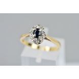 A 9CT GOLD SAPPHIRE AND DIAMOND CLUSTER RING, the oval sapphire within a single cut diamond