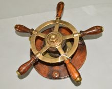 A WOODEN AND BRASS SHIPS WHEEL, mounted for wall hanging, approximate diameter 30cm