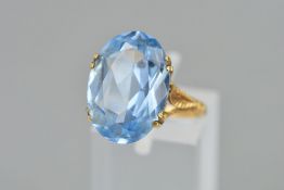A 9CT GOLD BLUE PASTE RING, the oval blue paste within a claw setting to the scroll engraved gallery