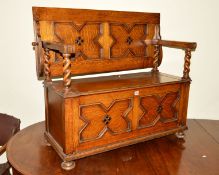 A 20TH CENTURY OAK BARLEY TWIST MONKS BENCH with hinged storage compartment, approximate width