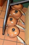 A SET OF FOUR GRADUATING LE CREUSET BROWN SAUCEPANS (well used)