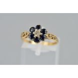 A 9CT GOLD SAPPHIRE AND DIAMOND CLUSTER RING, the central single cut diamond surrounded by