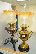 TWO OIL LAMPS WITH GLASS SHADES AND CHIMNEYS, the first being of brass construction with an ebonised